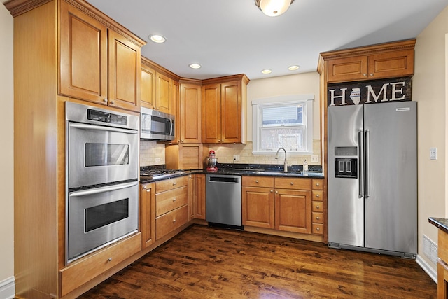 kitchen with tasteful backsplash, stainless steel appliances, dark wood-style floors, and a sink