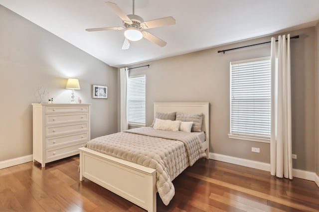 bedroom featuring baseboards, dark wood-style flooring, and vaulted ceiling
