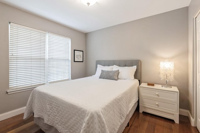 bedroom featuring baseboards and dark wood-style floors