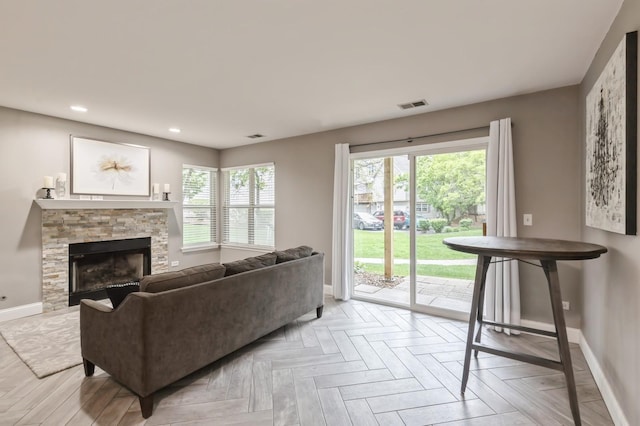 living area featuring baseboards, a fireplace, recessed lighting, and visible vents