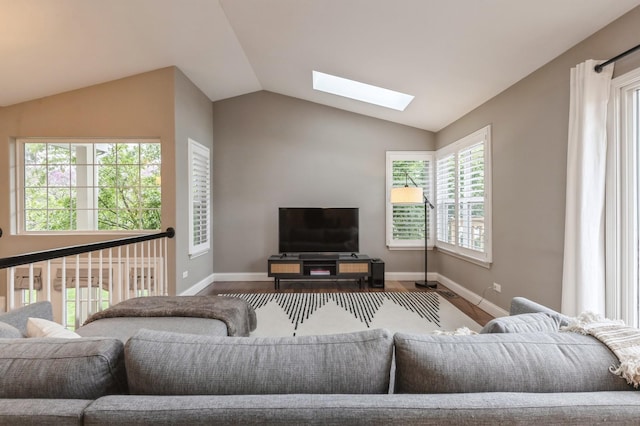 living area featuring baseboards, wood finished floors, and lofted ceiling with skylight