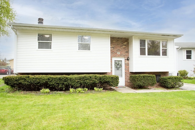 bi-level home with a front lawn and brick siding
