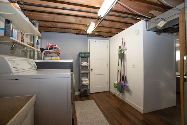 washroom with baseboards, washing machine and dryer, and dark wood-type flooring