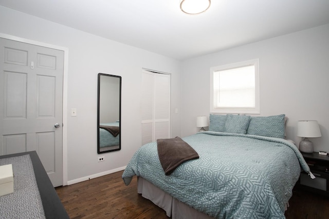 bedroom with baseboards, dark wood finished floors, and a closet