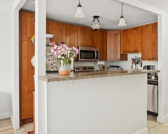 kitchen with a breakfast bar area, baseboards, decorative light fixtures, and appliances with stainless steel finishes