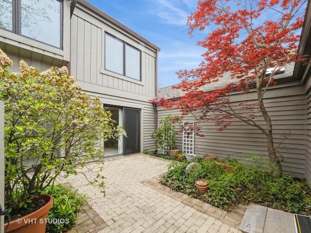 view of property exterior with board and batten siding and a patio