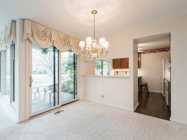 unfurnished dining area featuring a notable chandelier, visible vents, baseboards, and carpet