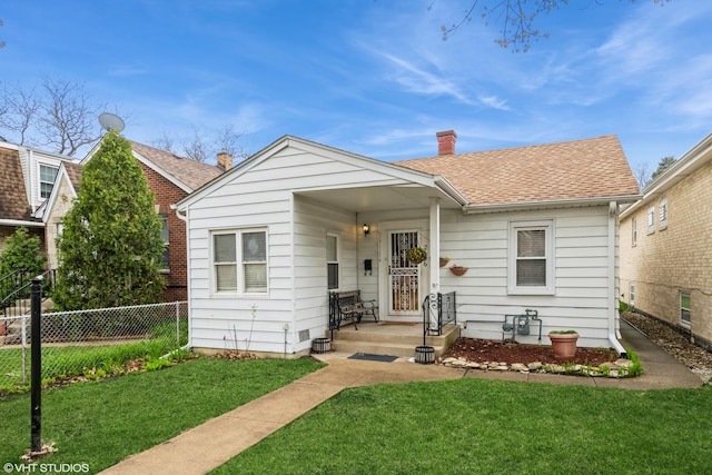 bungalow-style home featuring fence, a chimney, a shingled roof, and a front lawn