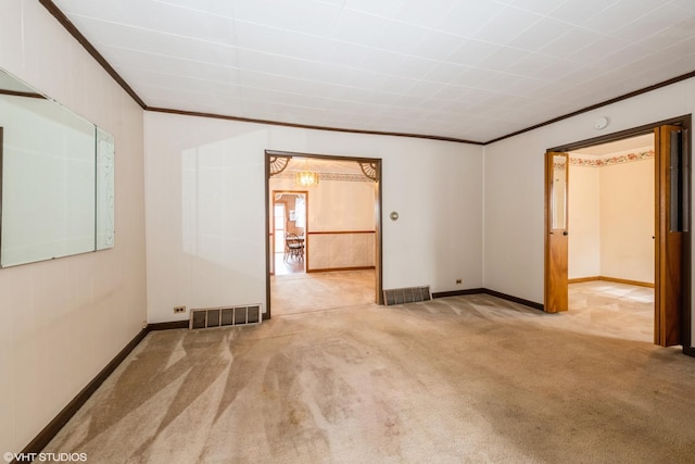 spare room featuring crown molding, baseboards, carpet flooring, and visible vents