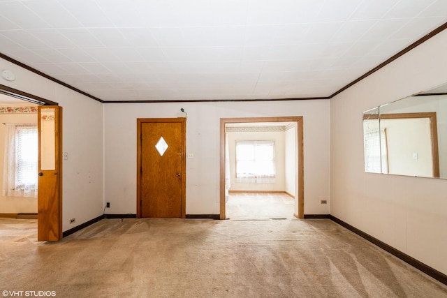entrance foyer with baseboards, carpet flooring, and ornamental molding