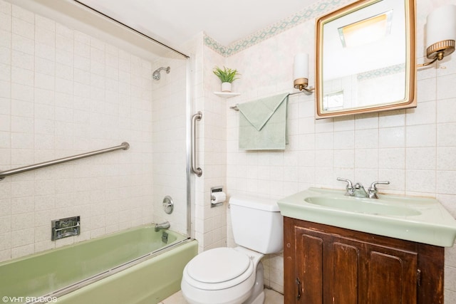 full bath featuring vanity, bathing tub / shower combination, toilet, and tile walls