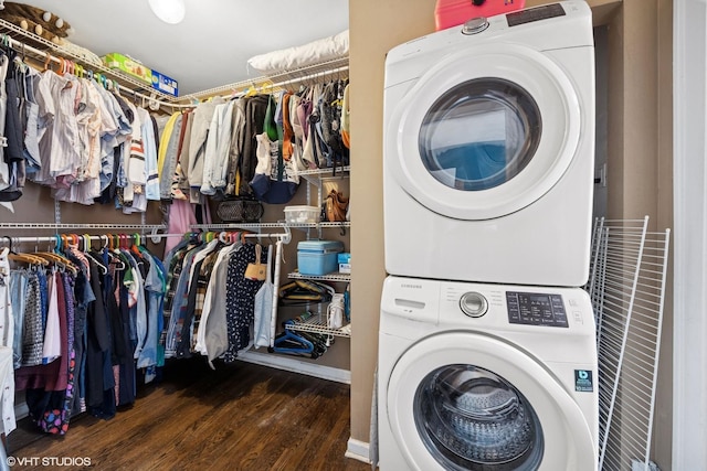 clothes washing area featuring laundry area, wood finished floors, and stacked washer / dryer