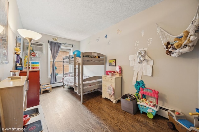 bedroom with a baseboard radiator, a textured ceiling, a wall mounted AC, and wood finished floors