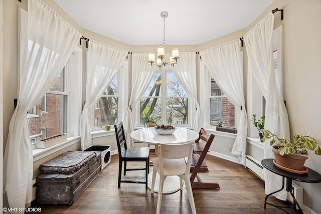 dining area featuring an inviting chandelier, baseboards, and dark wood-style floors
