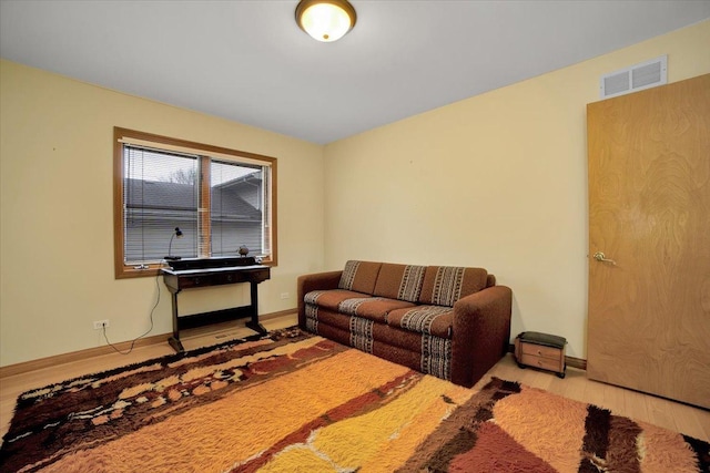 living room featuring baseboards, wood finished floors, and visible vents