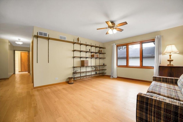 sitting room featuring baseboards, ceiling fan, light wood finished floors, and visible vents