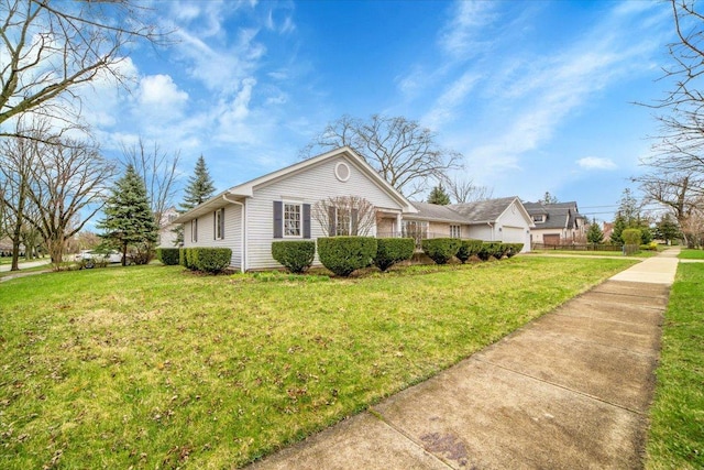 view of front of house featuring an attached garage, concrete driveway, and a front lawn