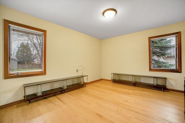 unfurnished room featuring baseboards and light wood finished floors