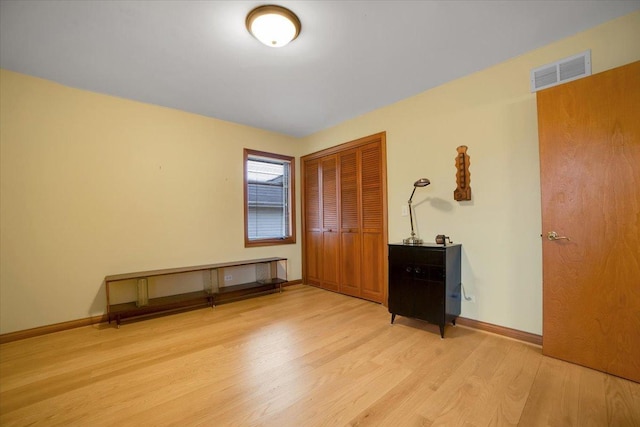 unfurnished bedroom featuring baseboards, a closet, light wood-type flooring, and visible vents