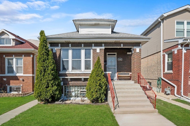 1314 S 59th Ct, Cicero, IL 60804 - bungalow featuring brick siding, roof with shingles, a front yard, and a porch
