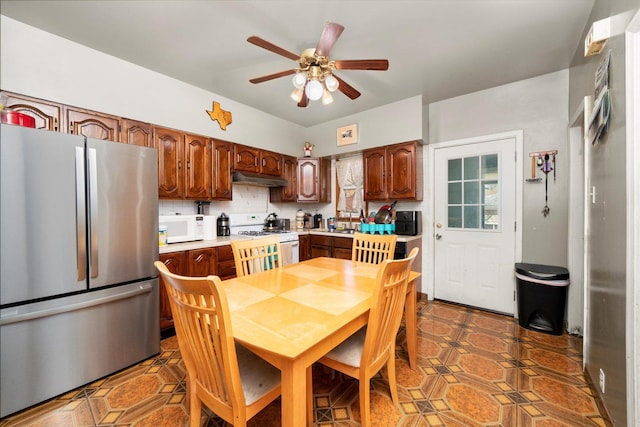 1314 S 59th Ct, Cicero, IL 60804 - kitchen featuring under cabinet range hood, white appliances, ceiling fan, light countertops, and tasteful backsplash