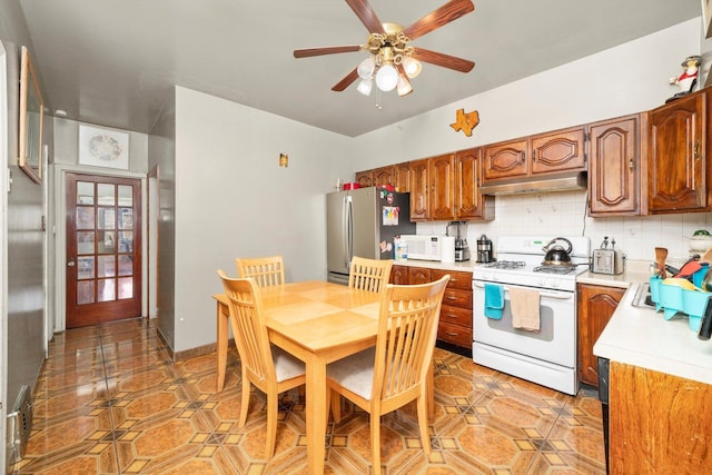 1314 S 59th Ct, Cicero, IL 60804 - kitchen featuring white appliances, under cabinet range hood, backsplash, light countertops, and a ceiling fan