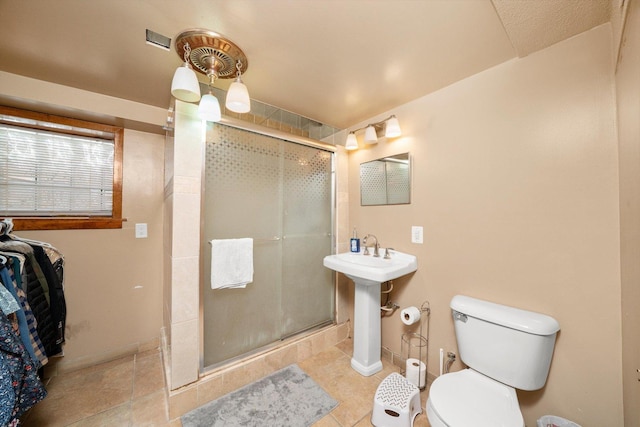 1314 S 59th Ct, Cicero, IL 60804 - bathroom featuring tile patterned floors, toilet, baseboards, and a stall shower