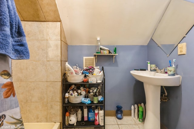 bathroom featuring tile patterned floors and lofted ceiling