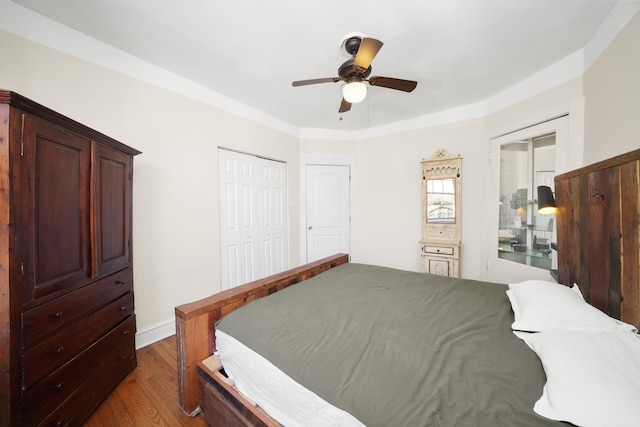 bedroom with dark wood finished floors, ceiling fan, and a closet