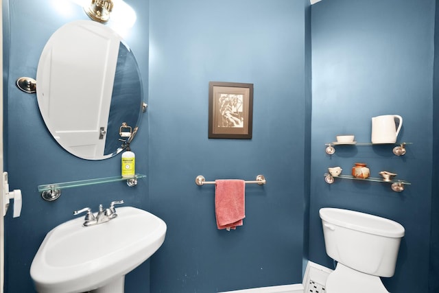 half bathroom featuring toilet and a sink