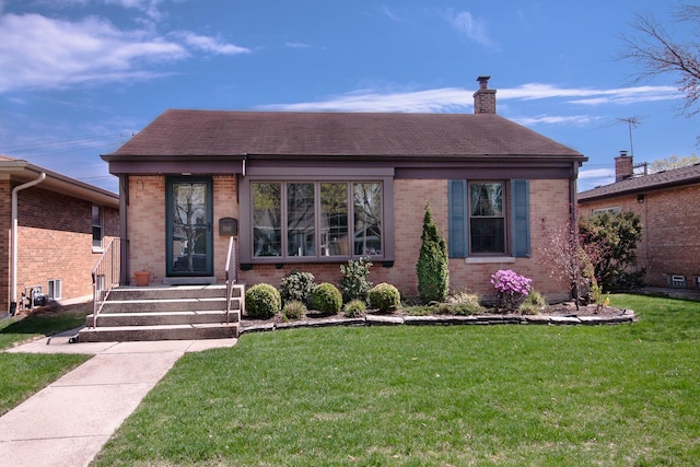 view of front of home with brick siding, a chimney, roof with shingles, and a front lawn