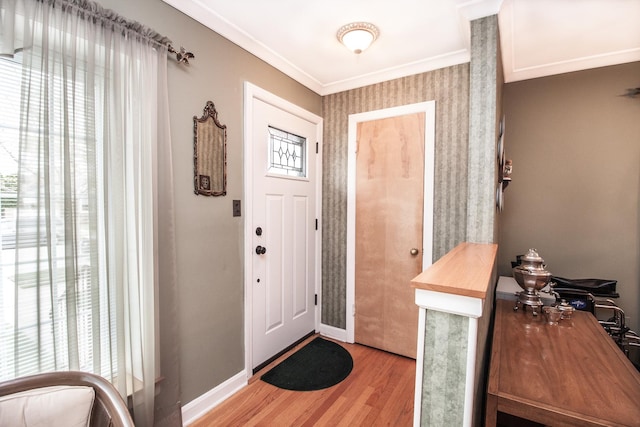 foyer with crown molding, baseboards, and light wood-type flooring