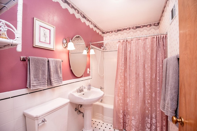 bathroom featuring visible vents, shower / bath combo, a sink, a wainscoted wall, and toilet