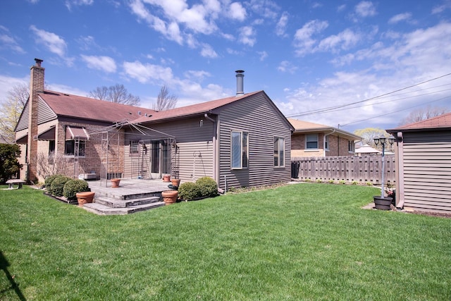 back of house with fence, a yard, a chimney, and a deck