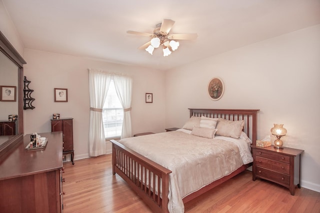 bedroom featuring baseboards, a ceiling fan, and light wood-style flooring
