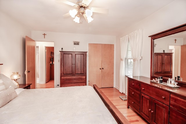 bedroom with a closet, a ceiling fan, visible vents, and light wood-type flooring