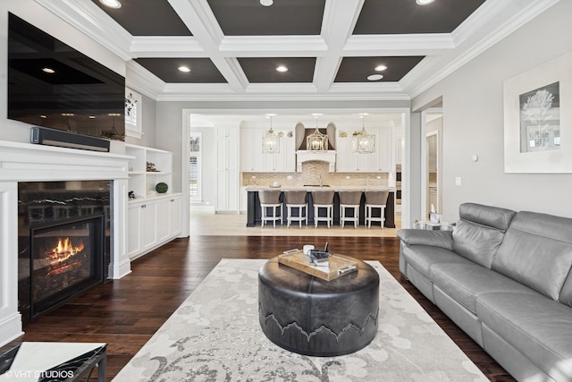 living room featuring crown molding, coffered ceiling, beam ceiling, and dark wood finished floors