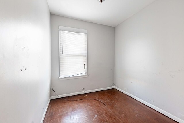 spare room featuring hardwood / wood-style floors and baseboards