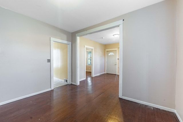 empty room featuring baseboards and hardwood / wood-style flooring