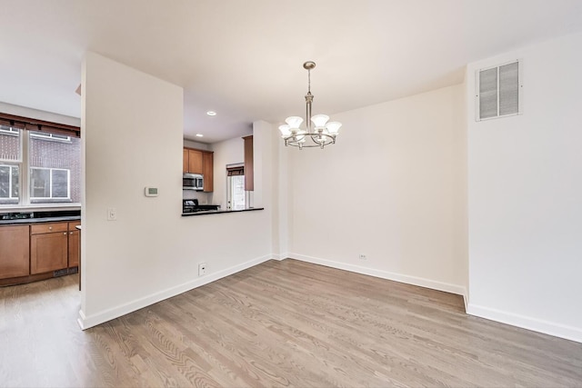 5350 N Damen Ave Unit F, Chicago, IL 60625 - unfurnished dining area featuring visible vents, a wealth of natural light, an inviting chandelier, and light wood finished floors