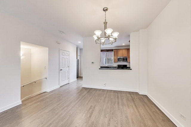 5350 N Damen Ave Unit F, Chicago, IL 60625 - unfurnished living room with baseboards, recessed lighting, light wood-style flooring, and a notable chandelier