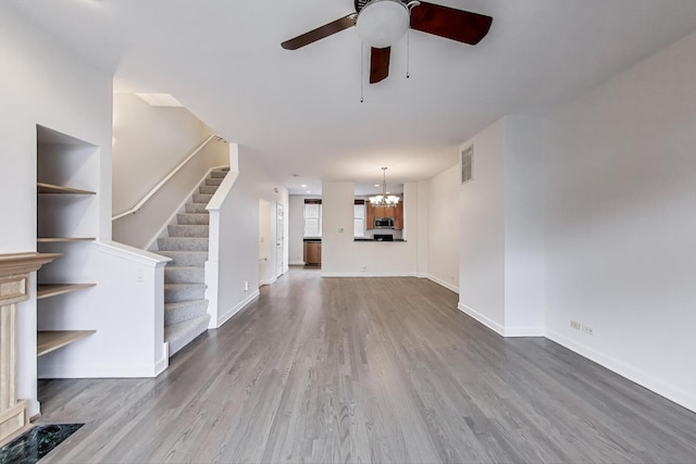 5350 N Damen Ave Unit F, Chicago, IL 60625 - unfurnished living room featuring baseboards, ceiling fan with notable chandelier, wood finished floors, and visible vents