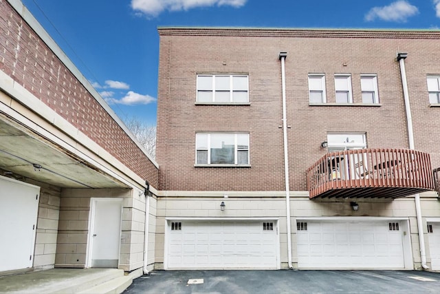5350 N Damen Ave Unit F, Chicago, IL 60625 - rear view of property with a garage, driveway, brick siding, and a balcony