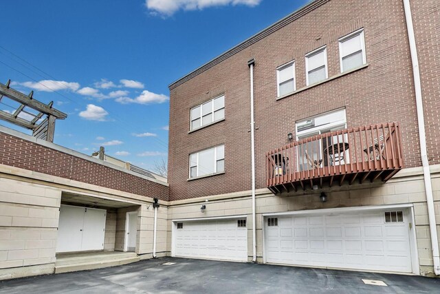 5350 N Damen Ave Unit F, Chicago, IL 60625 - rear view of property featuring an attached garage, a balcony, and driveway