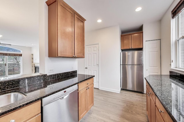 5350 N Damen Ave Unit F, Chicago, IL 60625 - kitchen featuring dark stone counters, stainless steel appliances, brown cabinetry, and light wood finished floors