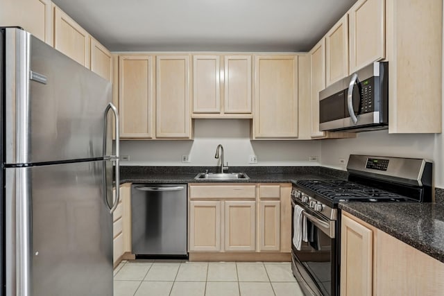 kitchen featuring a sink, light tile patterned floors, light brown cabinets, and stainless steel appliances
