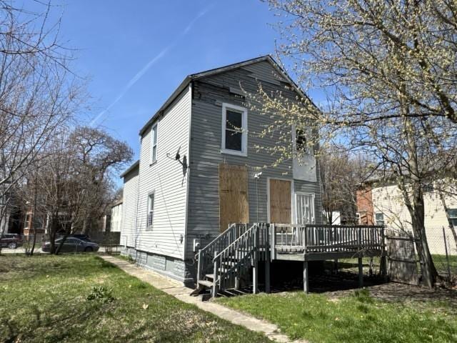exterior space with a front yard, stairway, and a wooden deck