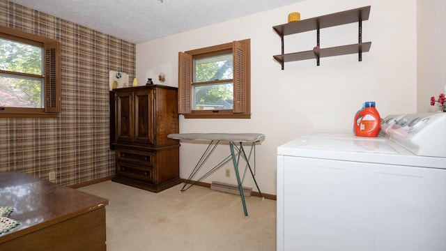 laundry room with light colored carpet, laundry area, washer and dryer, baseboards, and wallpapered walls