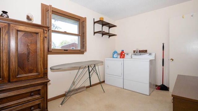 laundry area with laundry area, light colored carpet, baseboards, and independent washer and dryer