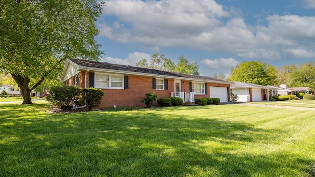 ranch-style house featuring a front yard, brick siding, a garage, and aphalt driveway